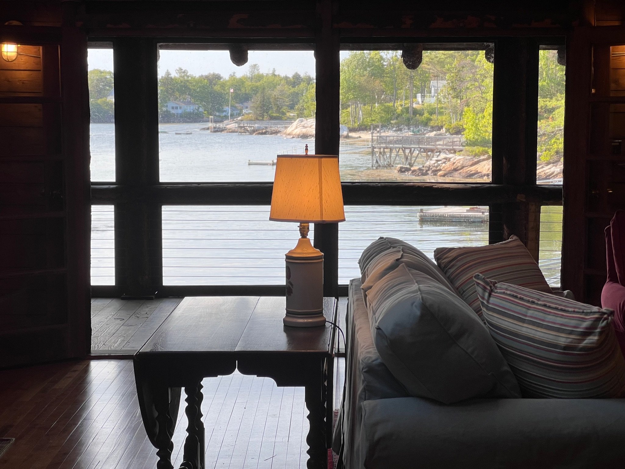 Cove-side sitting area with a sofa and large windows